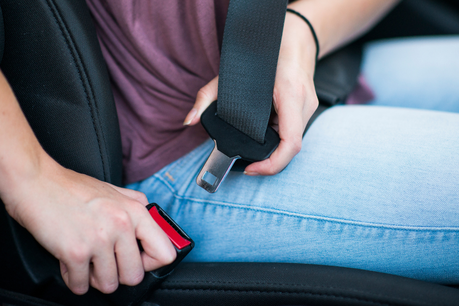 A woman buckling her seat belt